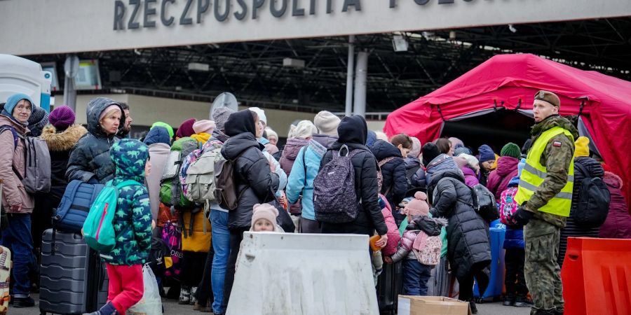 Geflüchtete warten an der ukrainisch-polnischen Grenze am Grenzübergang in Korczowa auf ihre Einreise nach Polen.