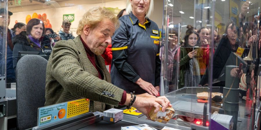 Thomas Gottschalk an einer Supermarkt-Kasse, das Geld aus der Aktion kommt sozialen Zwecken zugute.