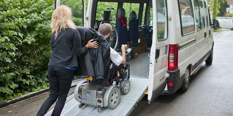 Ein Rollstuhlfahrer fährt 2009 mit Hilfe der Chauffeurin in Zürich in ein Behindertentaxi. (Archivbild)