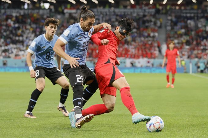 Heung-Min Son (Südkorea) gegen Martin Caceres (Uruguay) an der WM 2022. Uruguay Südkorea WM 2022