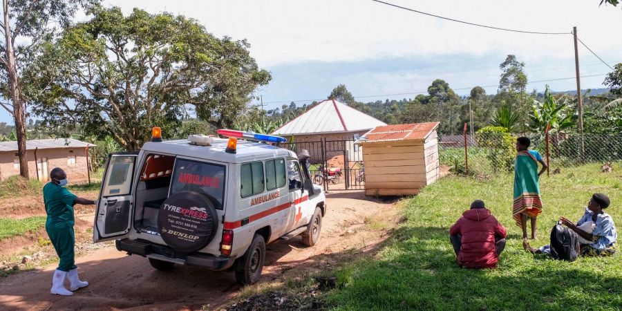 Ein medizinischer Mitarbeiter der Uganda Red Cross Society fordert Menschen mit Verdacht auf eine Ebola-Erkrankung dazu auf, in einen Krankenwagen einzusteigen.