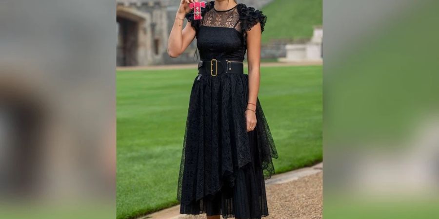 Strahlend präsentiert Emma Raducanu im Dior-Outfit ihren MBE-Orden.