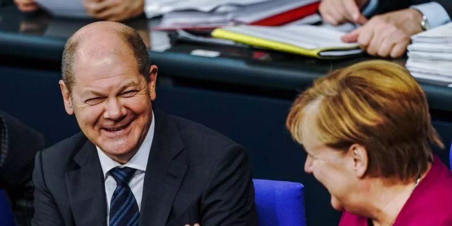 Gelöste Stimmung: Bundeskanzlerin Angela Merkel und Finanzminister Olaf Scholz präsentieren sich in der Generaldebatte als eingespieltes Paar. Foto: Michael Kappeler/dpa
