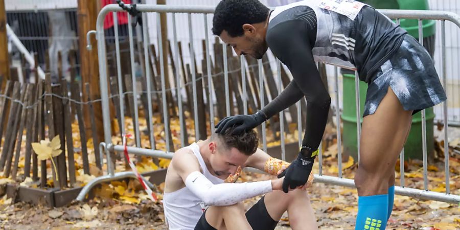 Julien Wanders (links am Boden) feiert an der Course de l'Escalade in Genf einen Hattrick mit Sieg und Streckenrekord und erhält Gratulationen von Tadesse Abraham (rechts), der Dritter wird