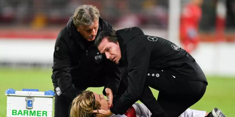Borna Sosa vom VfB Stuttgart wird von den Mannschaftsärzten behandelt. Foto: Tom Weller/dpa