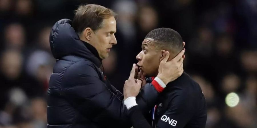 Kylian Mbappe (r) diskutiert mit Trainer Thomas Tuchel an der Seitenlinie. Foto: Christophe Ena/AP/dpa