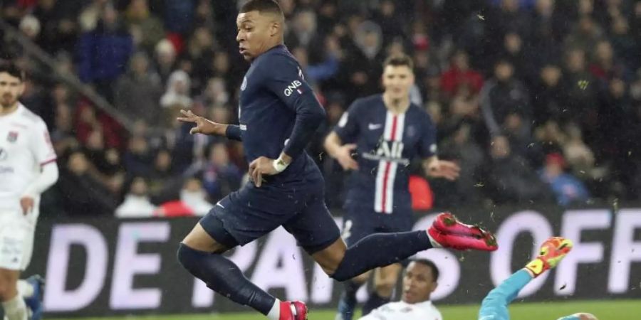 Paris Kylian Mbappe (M) erzielt gegen Lyons Torhüter Anthony Lopes (r) das zweite Tor seiner Mannschaft. Foto: Thibault Camus/AP/dpa