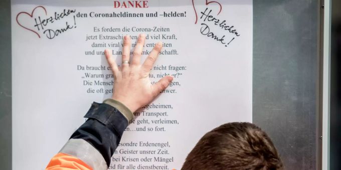 Solidarisches Stadtleben: Befestigung eines Dankesplakats mit Text zum Coronavirus von Stöff Sutter. Stadtleben