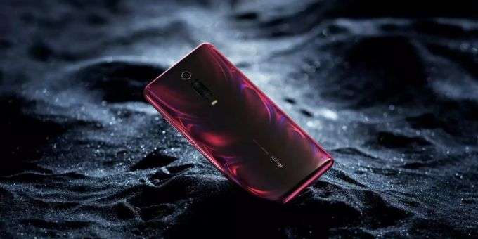 Die rote Variante des Xiaomi Redmi K20 liegt in bläulichem Sand. Xiaomi Redmi