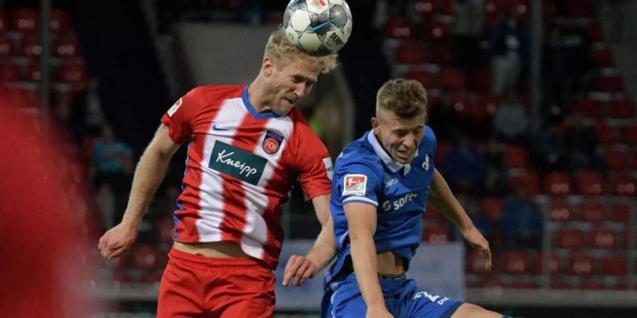 Heidenheims Sebastian Griesbeck (l) und Darmstadts Tim Skarke im Kopfballduell. Foto: Stefan Puchner