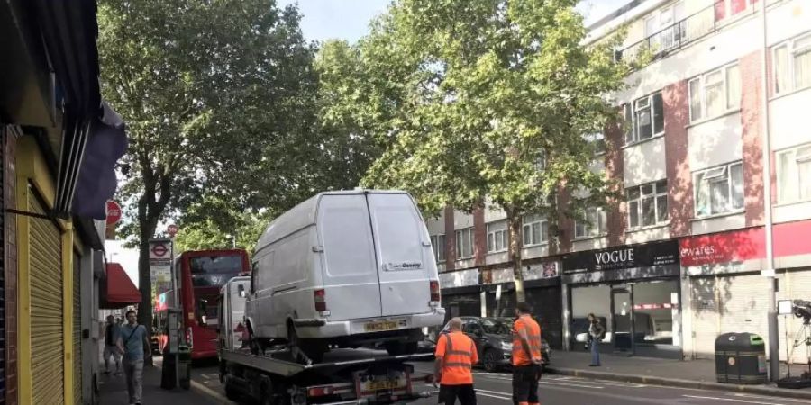 Ein Lieferwagen wird von zwei Männern auf einen Autotransporter verladen. Ein Mann hat in der Nacht zuvor mit einem Messer einen Polizisten angegriffen, als dieser den Lieferwagen angehalten hatte. Foto: Henry Vaughan/PA Wire