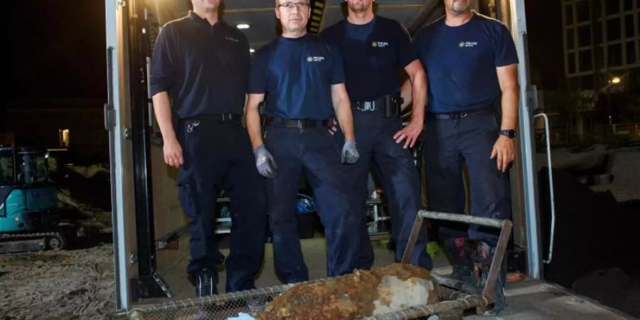 Die Polizeifeuerwerker stehen nach der erfolgreichen Entschärfung einer 100-Kilo-Fliegerbombe aus dem zweiten Weltkrieg am Alexanderplatz. Foto: Gregor Fischer