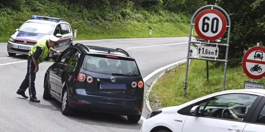 Hier geht's nicht weiter: Ein Polizist hält Autos auf einer Strasse bei Innsbruck an. Foto: Zeitungsfoto.At/Daniel Liebl/APA