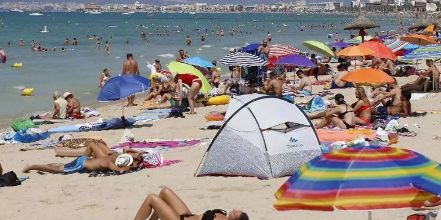 Hier darf weiter gequalmt werden: Touristen sonnen sich am Strand von El Arenal auf Mallorca. Foto: Clara Margais