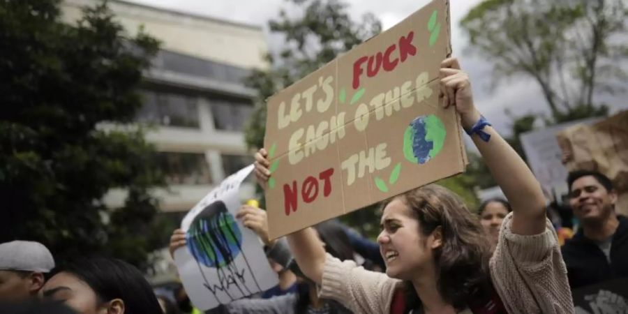 «Let's fuck each other, not the planet», steht auf dem Plakat einer Demonstrantin bei «Fridays for Future». Foto: colprensa