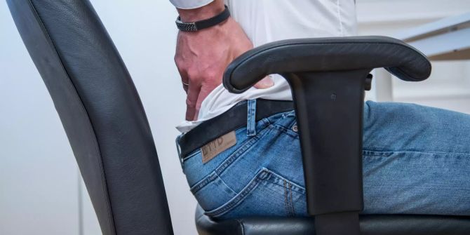 Mann Schreibtischstuhl Hand am hinteren Becken