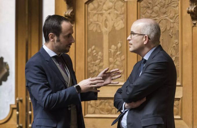 Die Nationalräte Christian Wasserfallen (FDP, links) und Gregor Rutz (SVP, rechts) diskutieren im Nationalratssaal. Christian Wasserfallen Gregor Rutz