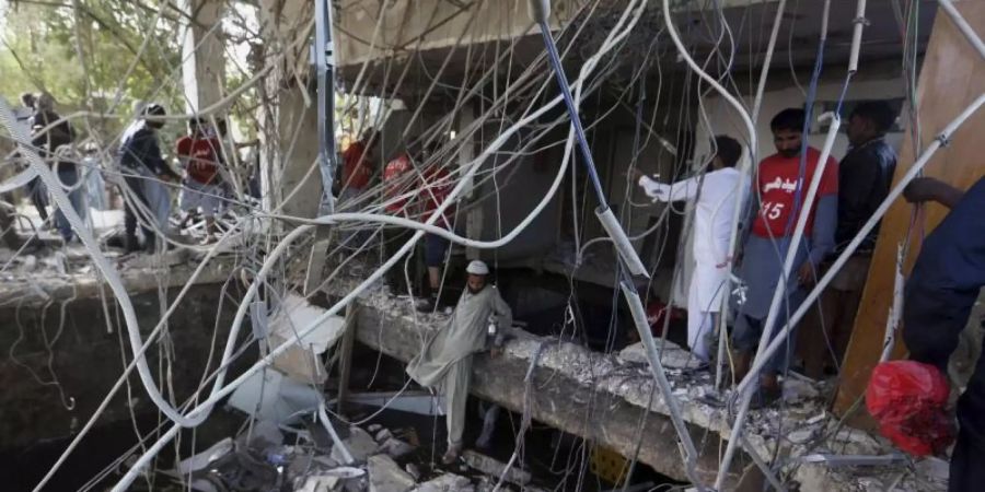Rettungskräfte untersuchen den Ort der Explosion. Foto: Fareed Khan/AP/dpa