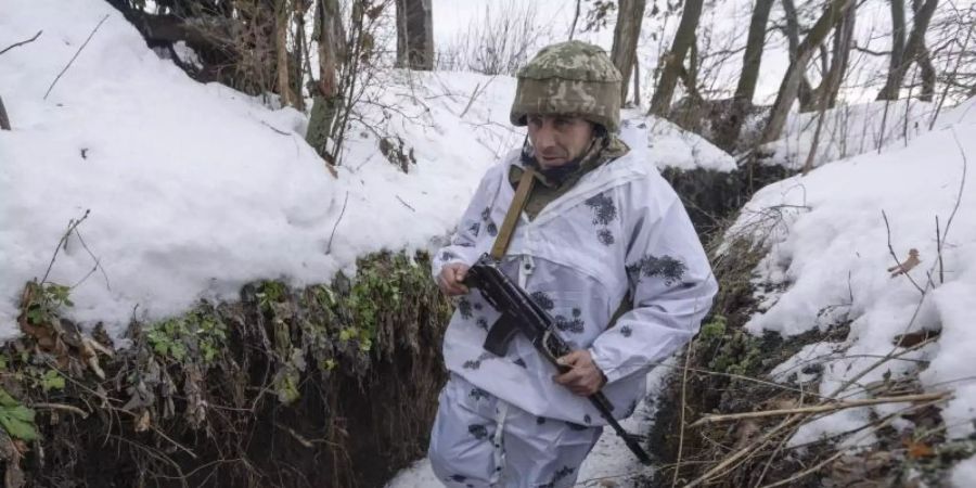 Ein ukrainischer Soldat geht an der Frontlinie zu prorussischen Rebellen in der Region Donezk in einem Schützengraben entlang. Foto: Andriy Dubchak/AP/dpa