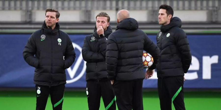 Vor dem Abflug nach Sevilla war Corona wieder ein Thema: Wolfsburgs Trainer Florian Kohfeldt (l) steht mit seinem Team zusammen. Foto: Swen Pförtner/dpa