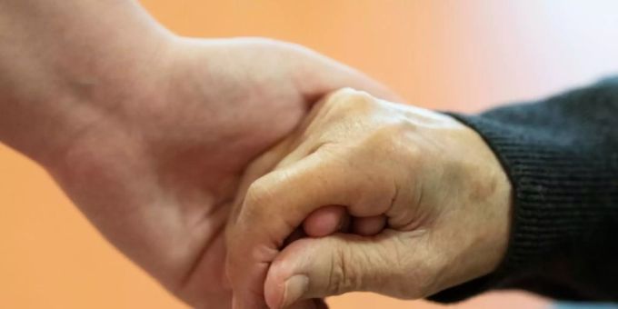 Pflegender hält die Hand eines alten Mannes Pflegender hält die Hand eines alten Mannes