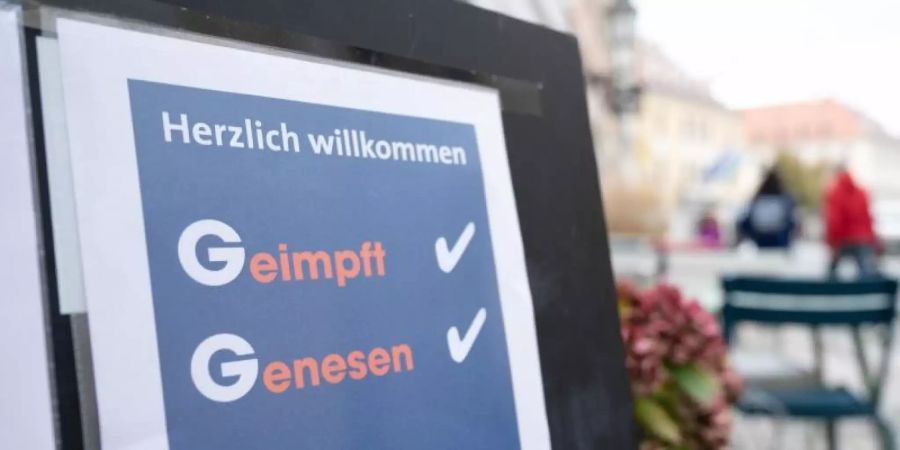 Eine Tafel vor einem Restaurant an der Hauptstrasse informiert die Gäste über die 2G-Regel mit der Aufschrift „Geimpft Genesen“. Foto: Sebastian Kahnert/dpa-Zentralbild/dpa