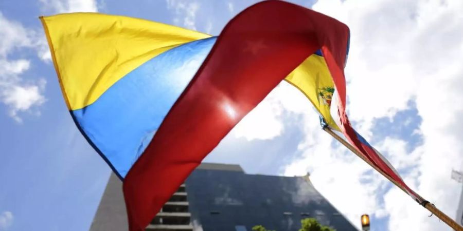 Die Fahne von Venezuela vor einem Gebäude in der Hauptstadt Caracas. Venezuelas Regierung hat den Dialog mit der Opposition nach der Auslieferung eines Vertrauten von Präsident Nicolás Maduro an die USA vorerst abgebrochen. Foto: Rafael Hernandez/dpa