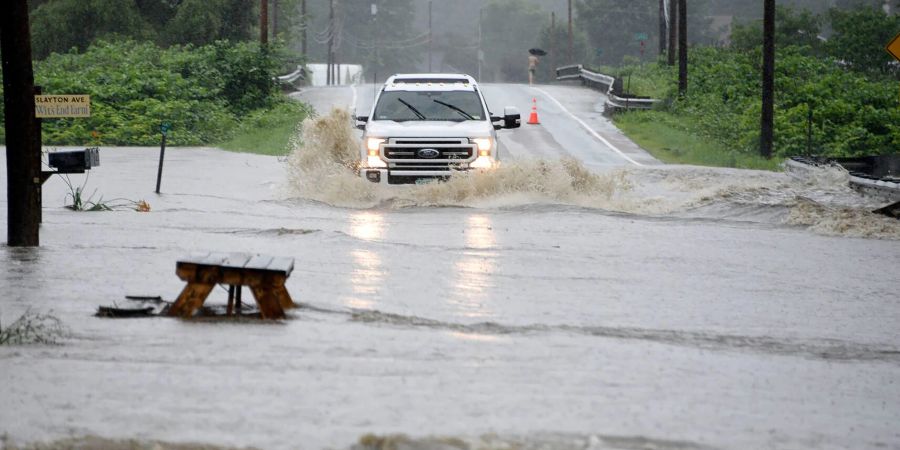 Ein Auto fährt über eine überschwemmte Strasse im US-Bundesstaat Vermont. Gouverneur Phil Scott nennt die Situation «historisch und katastrophal».