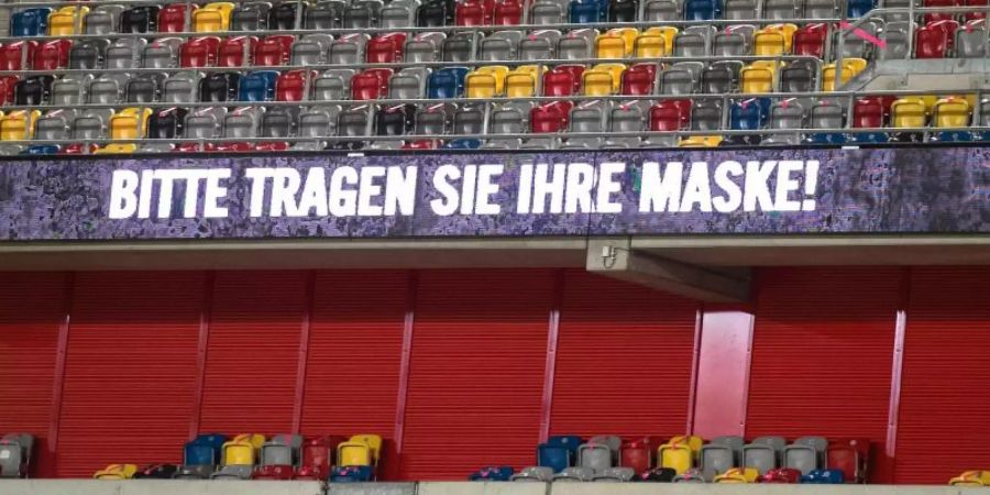 Appell ans Maskentragen bei einem Spiel der 2. Fussball-Bundesliga in Düsseldorf. Foto: Bernd Thissen/dpa