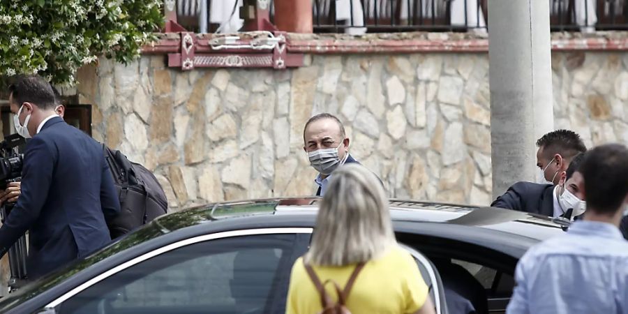Mevlüt Cavusoglu (M), Aussenminister der Türkei, trifft an einem Restaurant ein. Der türkische Aussenminister ist zu einem zweitägigen Besuch in Griechenland. Foto: Giannis Papanikos/AP/dpa