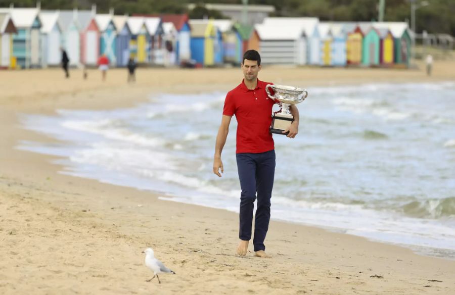 Der Serbe spaziert mit der Trophäe am Brighton Beach.