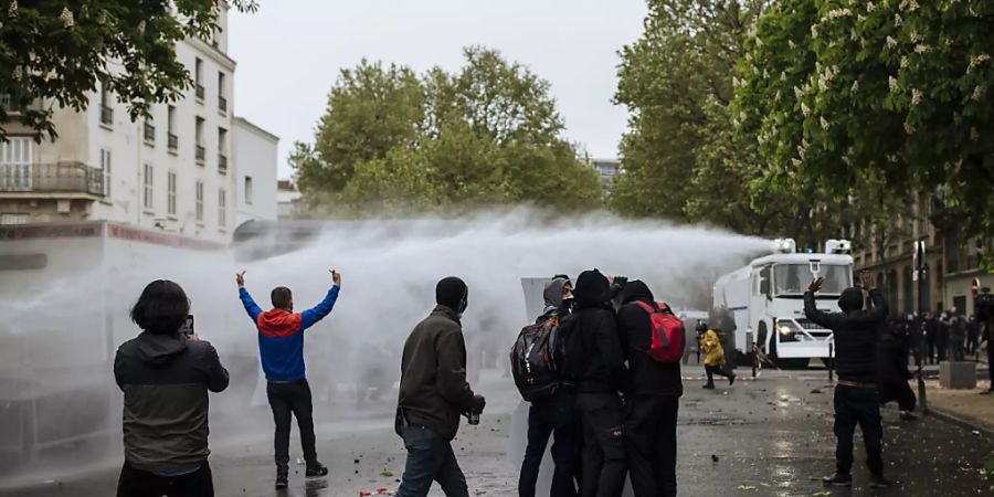 Polizisten setzen einen Wasserwerfer gegen Demonstranten auf dem Place de la Nation ein. Foto: Lewis Joly/AP/dpa