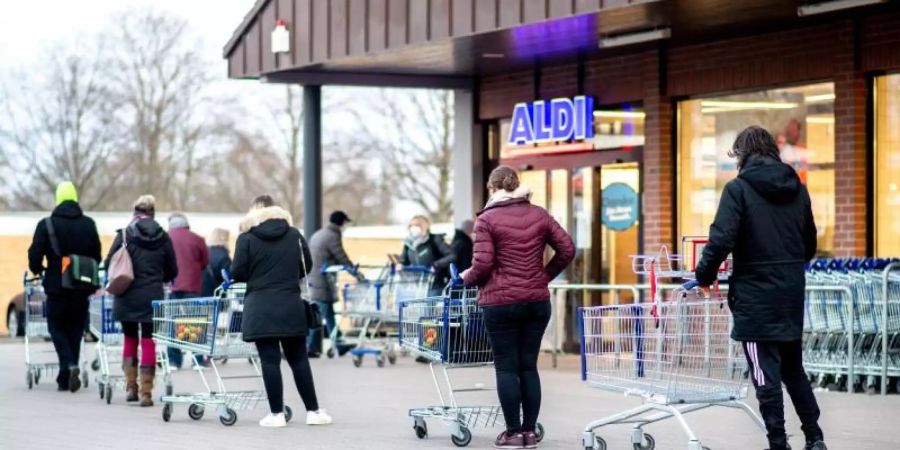 Zahlreiche Kunden warten auf die Öffnung einer Filiale von Aldi in Hannover. Der Discounter bietet nun Corona-Schnelltests zu Verkauf an. Foto: Hauke-Christian Dittrich/dpa