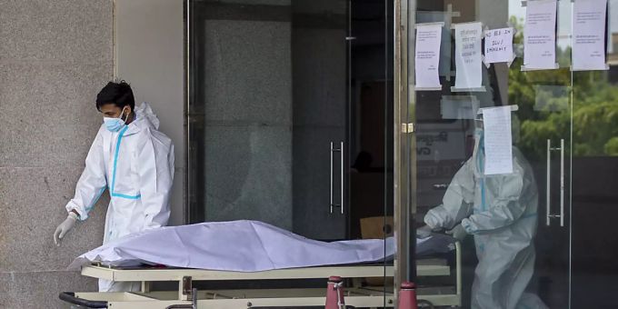 Medizinische Mitarbeiter in Schutzausrüstung transportieren den Leichnam eines Corona-Toten auf einer Trage aus einem Krankenhaus für Corona-Patienten. Foto: Altaf Qadri/AP/dpa Medizinische Mitarbeiter in Schutzausrüstung transportieren den Leichnam eines Corona-Toten auf einer Trage aus einem Krankenhaus für Corona-Patienten. Foto: Altaf Qadri/AP/dpa