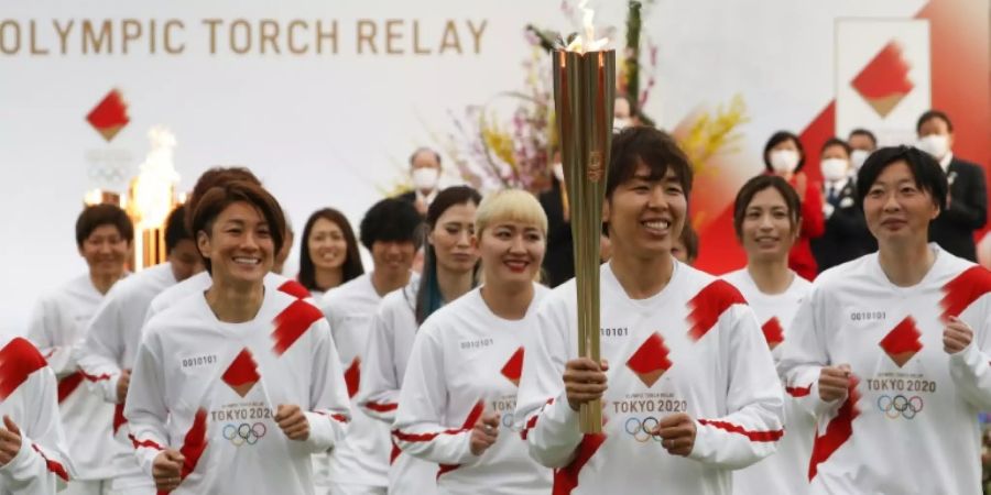 Mitglieder des japanischen Fussball-Nationalteams der Frauen entzündeten die Fackel