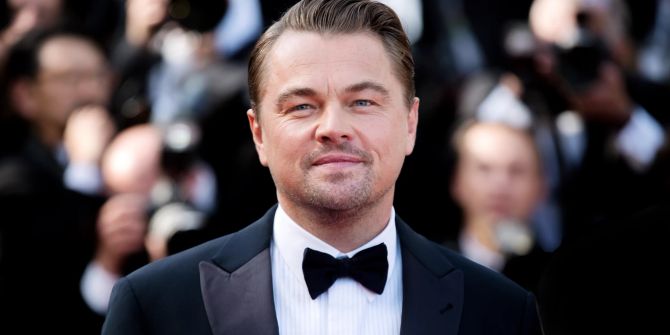 Leonardo DiCaprio mit Smoking und Fliege im Hintergrund Fotografen.