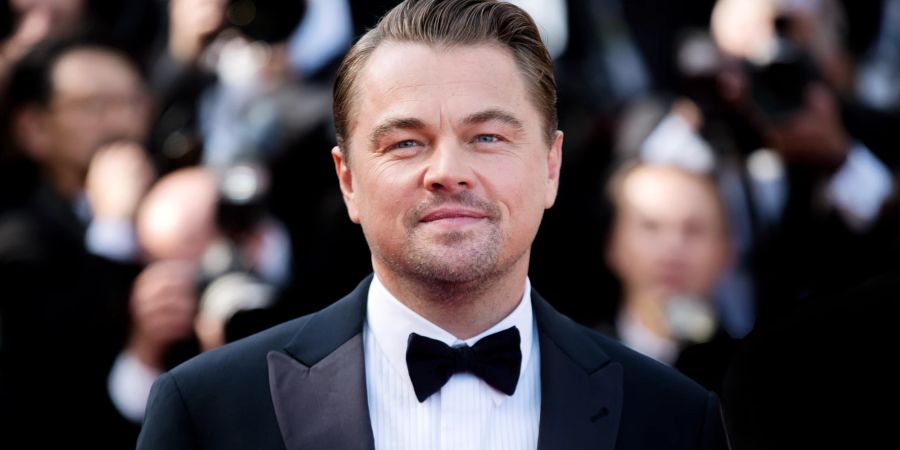 Leonardo DiCaprio mit Smoking und Fliege im Hintergrund Fotografen