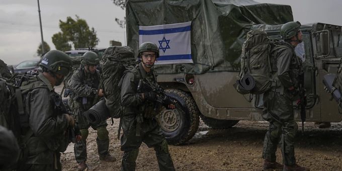 Israelische Soldaten stehen neben Militärfahrzeugen während sie sich an einem Sammelpunkt nahe der Grenze zum Gazastreifen vorbereiten. Israel Krieg