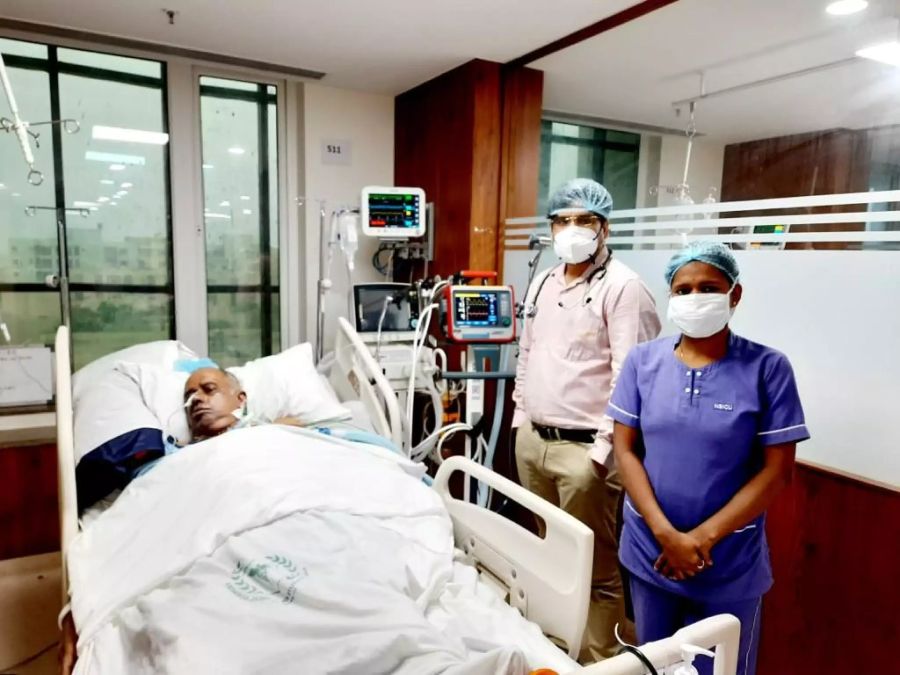 Ein Arzt und eine Pflegefachfrau stehen neben einem Covid-Patienten im Covid-Spital in Odisha, Indien.