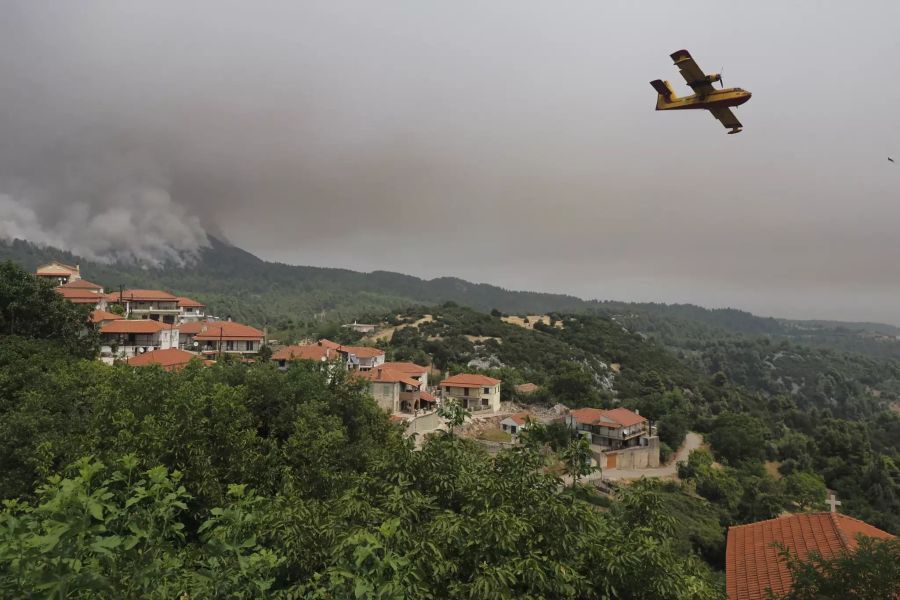 Ein Löschflugzeug operiert während eines Waldbrandes im Dorf Kourkouloi.