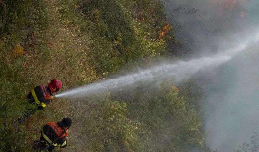 Feuerwehrleute bei Löscharbeiten.