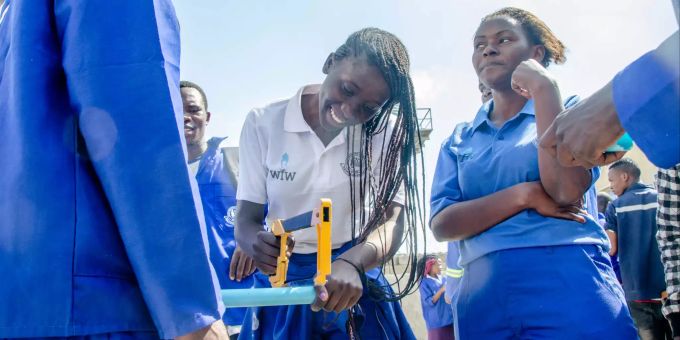 Berufsschülerinnen besuchen einen von WfW finanzierten Sanitär-Workshop in Lusaka, Sambia. Frau sägt Rohr