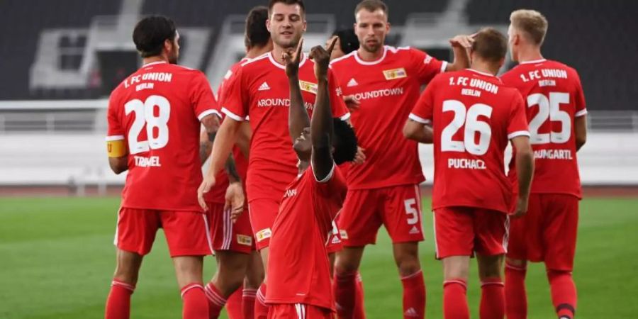 Unions Spieler feiern gemeinsam, nachdem Taiwo Awoniyi (vorne) zur 1:0-Führung getroffen hat. Foto: Matthias Koch/dpa