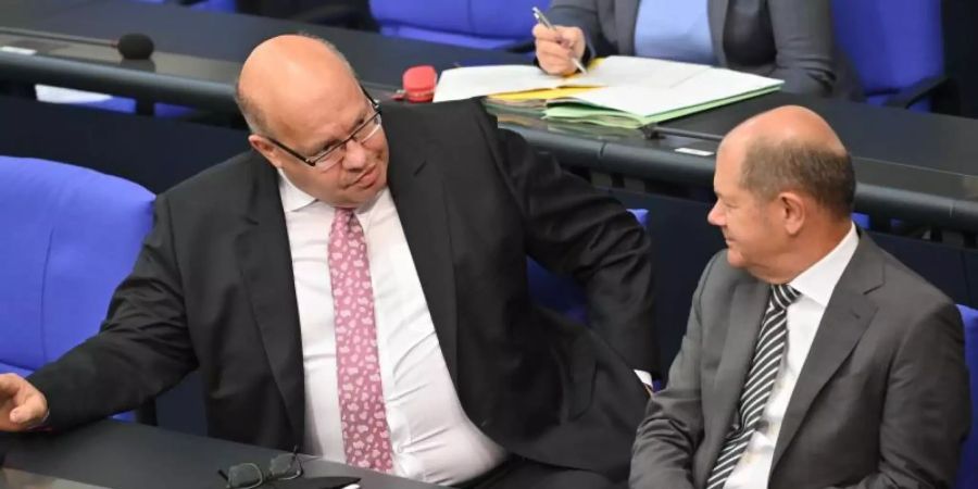 Bundesfinanzminister Olaf Scholz (SPD, r) spricht mit Bundeswirtschaftsminister Peter Altmaier (CDU) bei einer Sondersitzung des Deutschen Bundestages. Foto: Bernd Von Jutrczenka/dpa