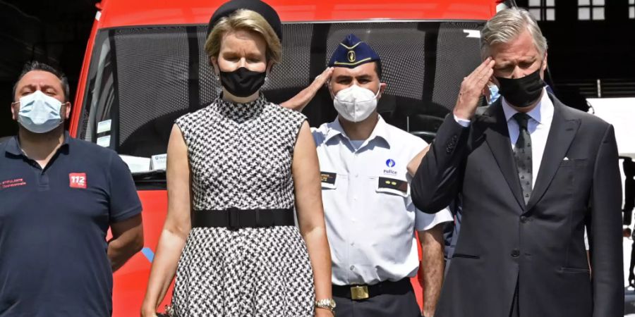 Königin Mathilde von Belgien und König Philippe von Belgien (r) halten eine Schweigeminute ab. Belgien gedenkt heute im Rahmen eines Staatstrauertags der Opfer der Hochwasserkatastrophe. Nach Angaben des Nationalen Krisenzentrums starben in Belgien mindestens 31 Menschen in den Fluten. Foto: Pool Philip Reynaers/BELGA/dpa