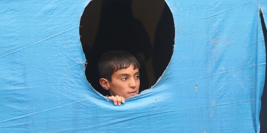 Ein Junge blickt im Flüchtlingslager Al-Hol im Nordostens Syriens aus einem Zelt.