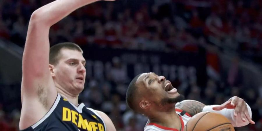 Damian Lillard (r) von den Portland Trail Blazers verteidigt gegen Nikola Jokic von den Denver Nuggets. Foto: Craig Mitchelldyer/AP