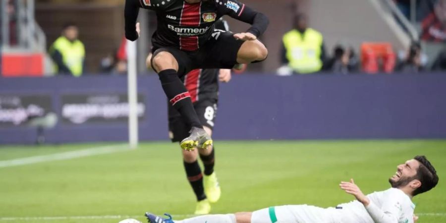 Leverkusens Karim Bellarabi (l) wird seinem Team nach einer Oberschenkelverletzung bis zum Saisonende fehlen. Foto: F. Gambarini/dpa