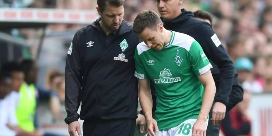 Werder Trainer Florian Kohfeldt spricht mit dem verletzt ausgewechselten Niklas Moisander (r). Foto: Carmen Jaspersen/dpa