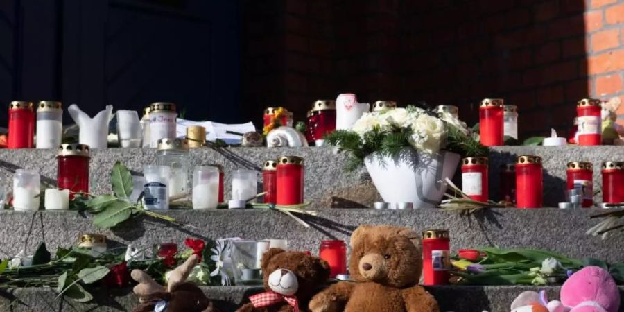 Stofftiere, Blumen und Kerzen liegen Anfang Februar vor dem Eingang der Grundschule in Berlin. Foto: Paul Zinken